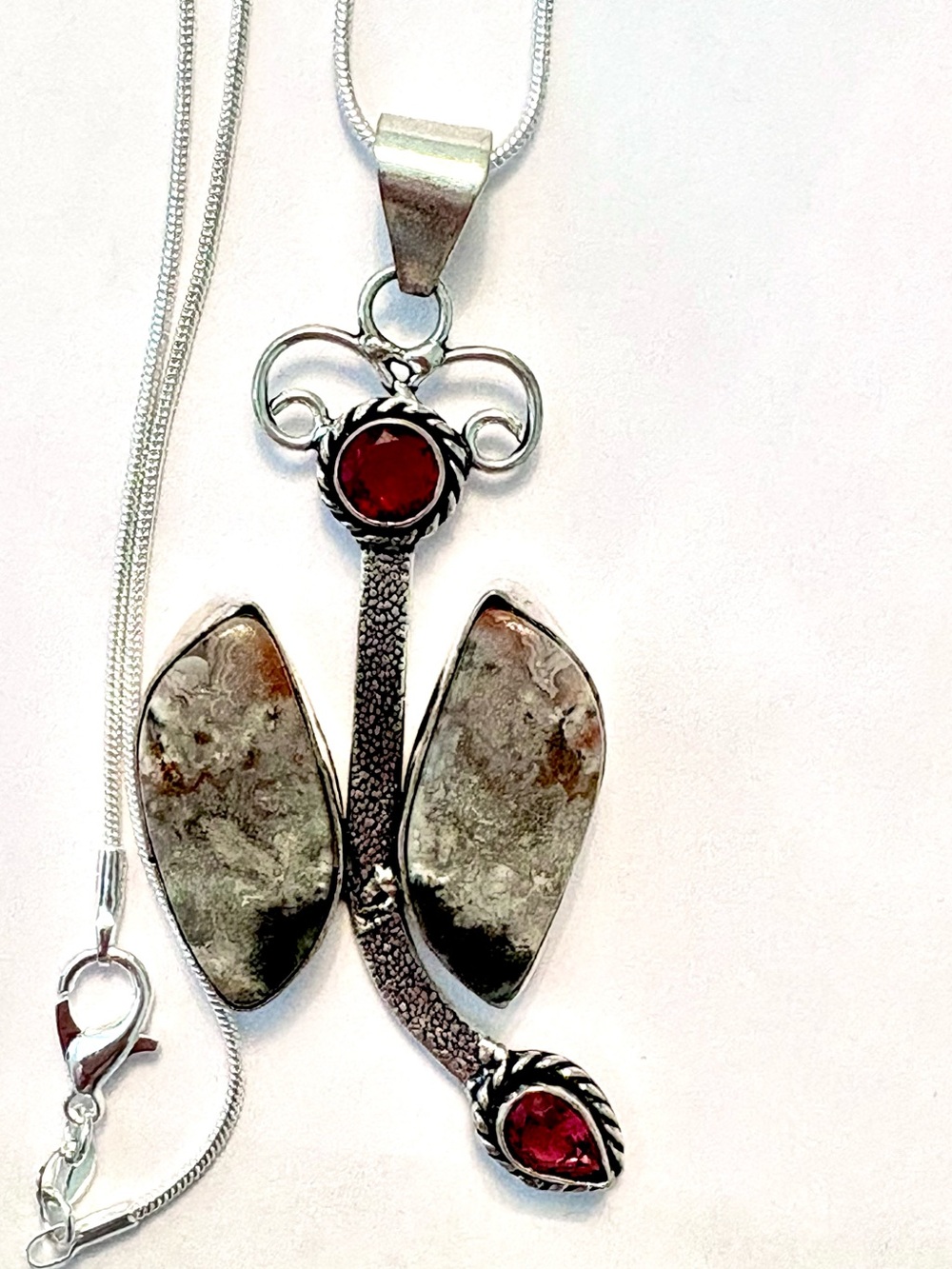2 1/2 inch, 925 marked, Crazy  Lace Agate and Garnet pendant on a silver chain.
